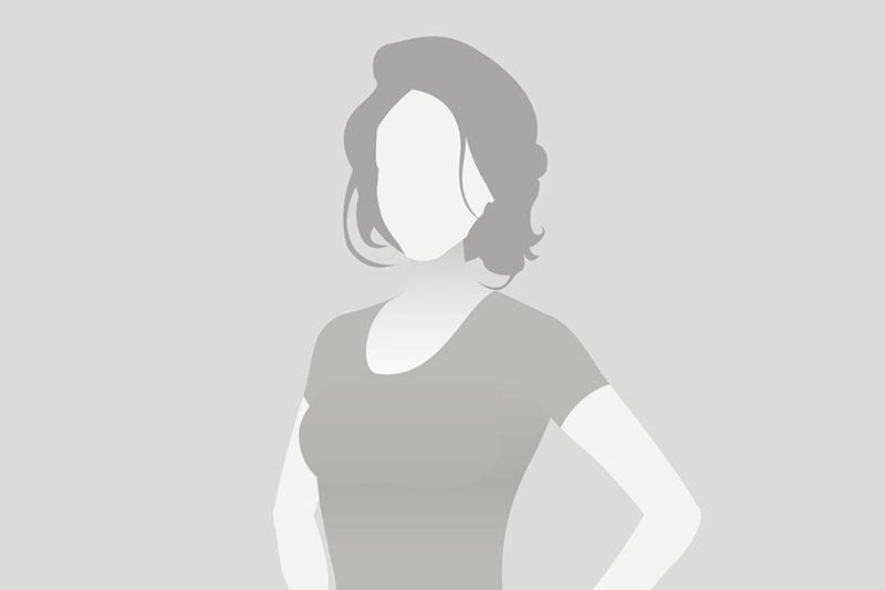 Silhouettenbild einer Frau mit kurzen Haaren, die lässig in einem T-Shirt steht, vor grauem Hintergrund.