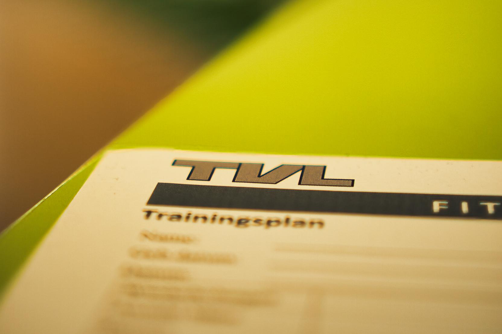 Nahaufnahme eines Trainingsplans mit der Überschrift „TVL“ auf einem grünen Tisch.