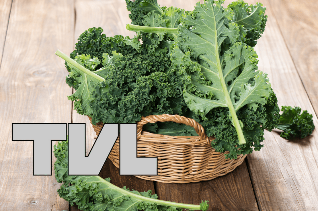 Ein Korb mit frischen Gr&uuml;nkohlbl&auml;ttern auf einer Holzoberfl&auml;che.